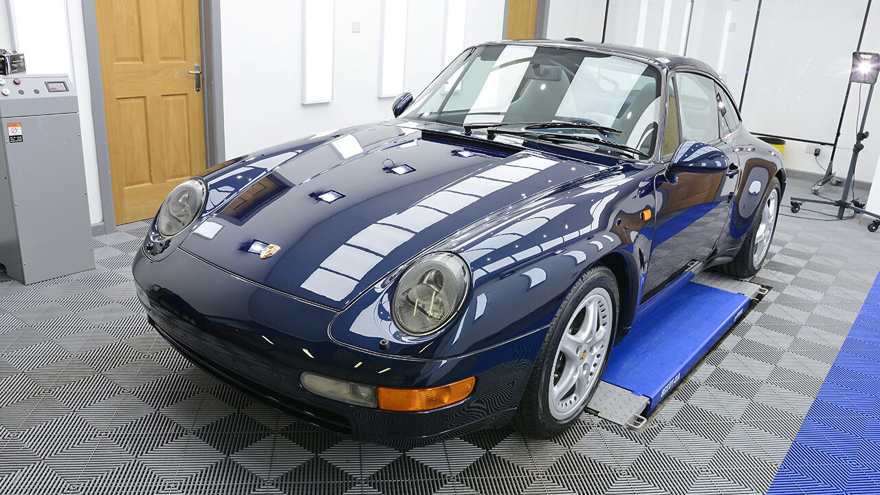 Blue Porsche 911 after paint correction in Toronto, showing clear reflections across the hood